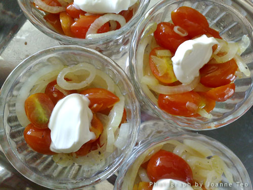 Softened onions and tomatoes in a buttered ramekin with a dollop of cream Softened onions and tomatoes in a buttered ramekin with a dollop of cream