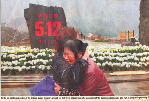 Scan of Reuters photo of Donghekou Earthquake Park in Qingchuan On the six-month anniversary of the Sichuan quake, mourners grieved for their loved ones in front of a monument at the Donghekou Earthquake Site Park in Qingchuan yesterday.